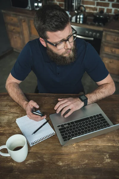 El hombre trabajando con el ordenador portátil - foto de stock