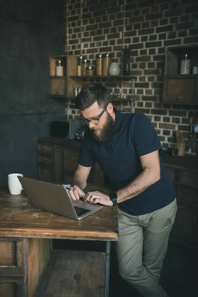 Білий чоловік працює на ноутбуці вдома — стокове фото
