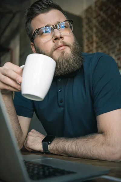 Giovane uomo barbuto bere caffè — Foto stock