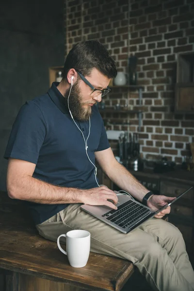 Casual man using laptop at home — Stock Photo
