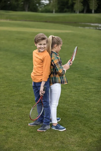 Hermanos con raquetas de bádminton - foto de stock