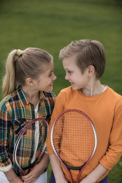 Frères et sœurs avec raquettes de badminton — Photo de stock