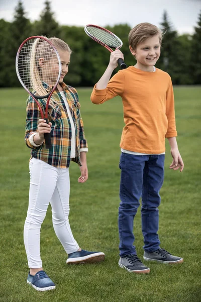 Geschwister mit Badmintonschlägern — Stockfoto