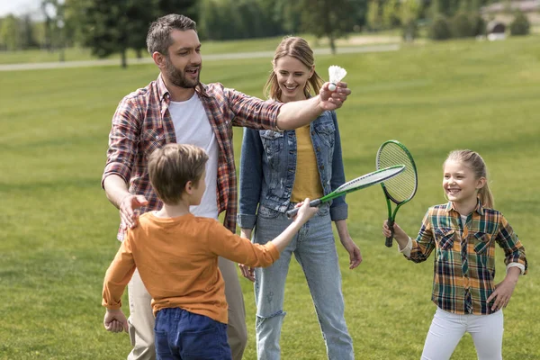 Familia feliz jugando bádminton en el parque - foto de stock