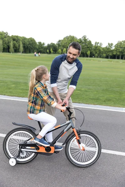 Père enseignement fille équitation sur vélo — Photo de stock