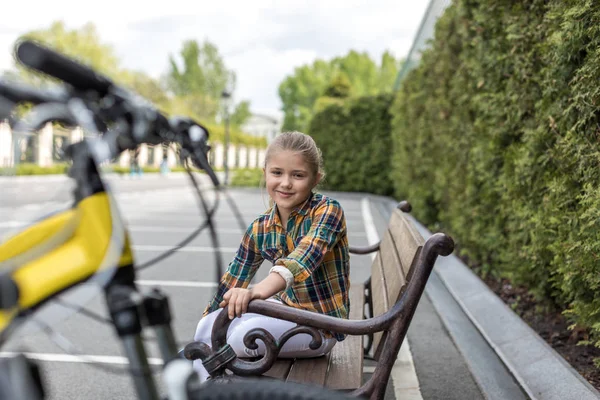 Vorpubertierendes Mädchen sitzt auf Parkbank — Stockfoto