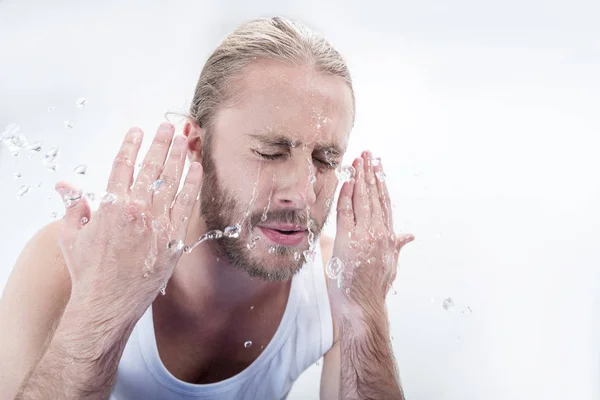 Junger Mann wäscht Gesicht — Stockfoto