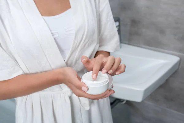 Mulher segurando creme facial — Fotografia de Stock