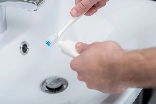 Hombre con cepillo de dientes y pasta de dientes - foto de stock