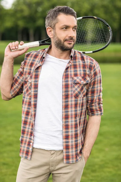 Hombre sosteniendo raqueta de bádminton - foto de stock