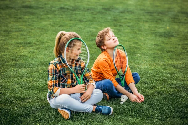 Siblings with badminton racquets — Stock Photo