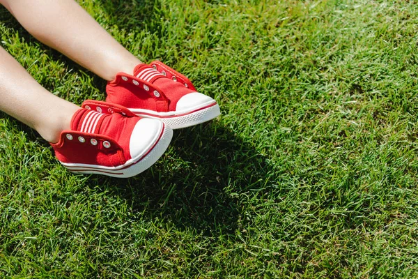 Дитина в кросівках на траві — стокове фото