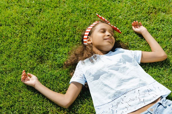 Africano menina americana dormindo na grama — Fotografia de Stock