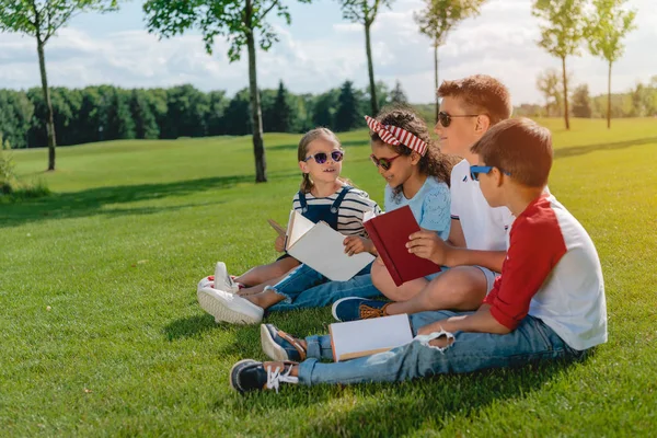 Enfants lisant des livres dans le parc — Photo de stock