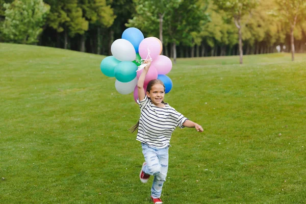 Girl with colorful balloons in park — Stock Photo