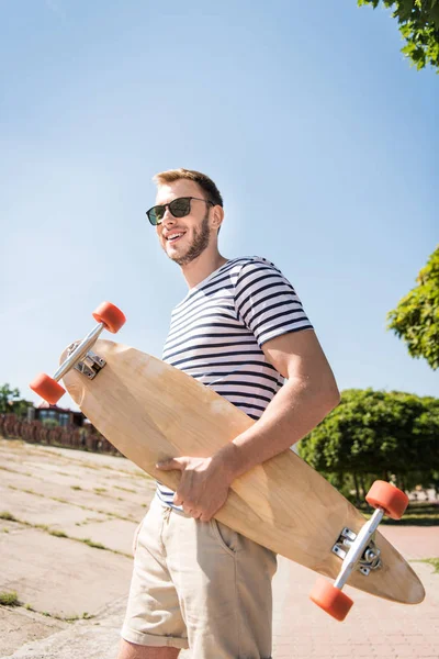 Homme tenant skateboard — Photo de stock