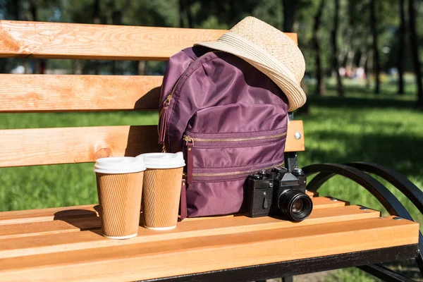 Backpack with camera and paper cups — Stock Photo