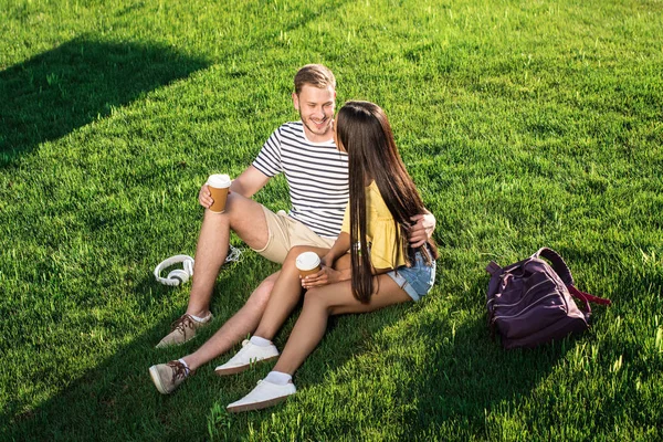 Pareja multiétnica con vasos de papel - foto de stock