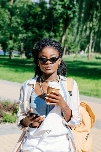 Mujer afroamericana con café y smartphone - foto de stock