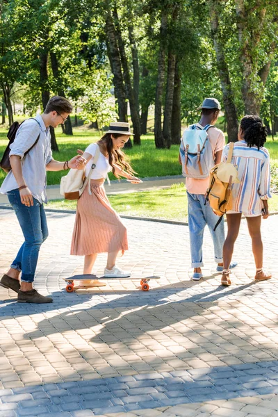 Amigos multiétnicos caminando en el parque - foto de stock
