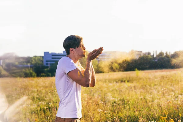 Man blowing colorful dust — Stock Photo