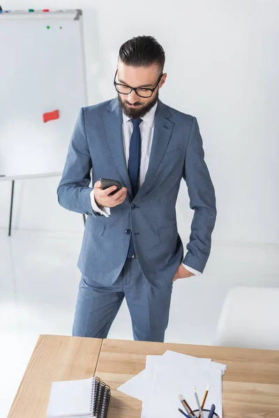 Uomo d'affari che utilizza Smartphone in ufficio — Foto stock