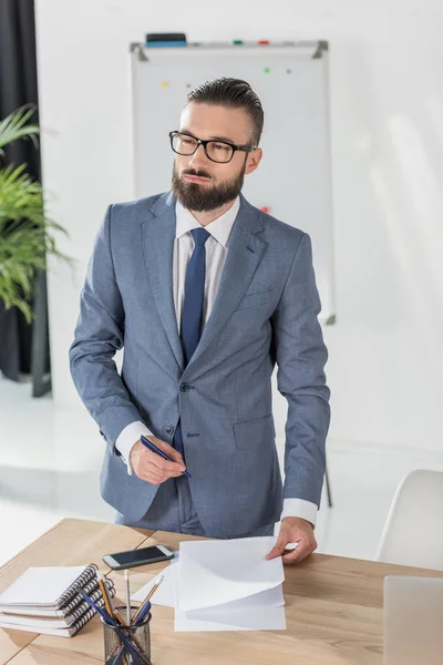 Empresario pensativo en el lugar de trabajo - foto de stock