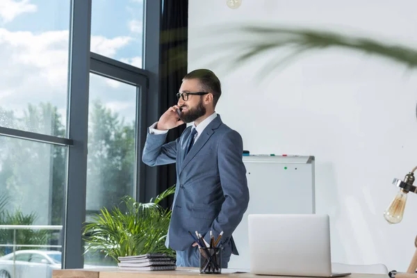 Бизнесмен разговаривает на смартфоне на рабочем месте — Stock Photo