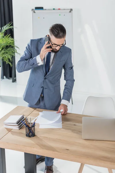 Empresário falando no smartphone no local de trabalho — Fotografia de Stock