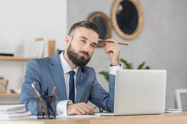 Geschäftsmann sitzt mit Laptop am Arbeitsplatz — Stockfoto