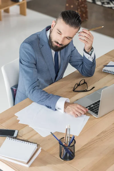 Businessman at workplace with laptop — Stock Photo