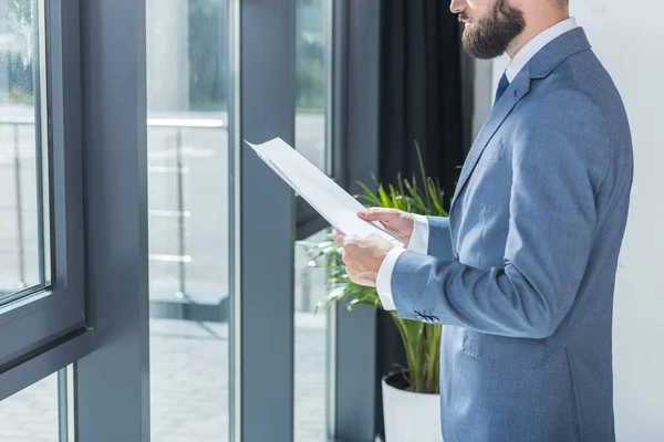 Homme d'affaires avec documents en fonction — Photo de stock