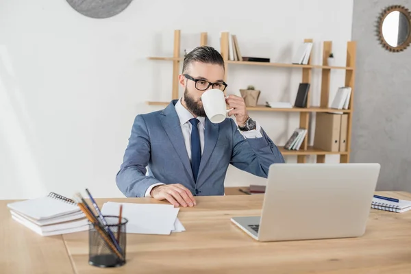 Homme d'affaires buvant du café sur le lieu de travail — Photo de stock