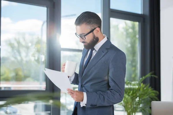 Бізнесмен з чашкою кави та паперами — Stock Photo