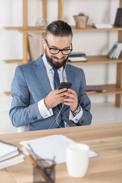 Uomo d'affari ascoltare musica sul posto di lavoro — Foto stock