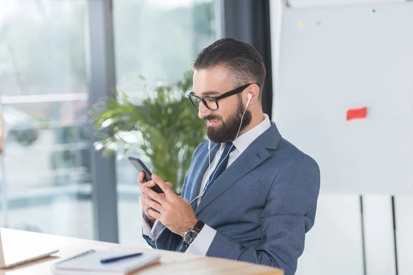 Homme d'affaires écouter de la musique sur le lieu de travail — Photo de stock