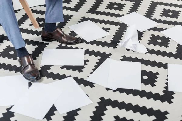 Businessman legs and empty papers — Stock Photo