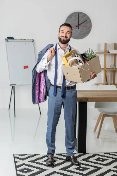 Fired smiling businessman with cardboard box — Stock Photo