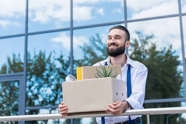 Уволен счастливый бизнесмен с картонной коробкой — стоковое фото