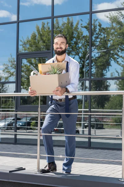 Fired happy businessman with cardboard box — Stock Photo