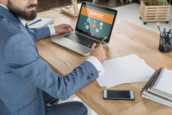 Empresario sentado en el lugar de trabajo con papeles - foto de stock