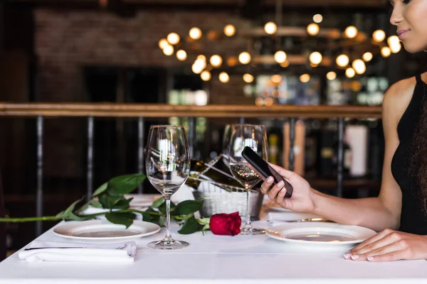 Frau benutzt Smartphone in Restaurant — Stock Photo