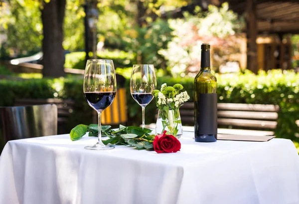 Rosenblüte mit Wein am Tisch im Restaurant — Stockfoto