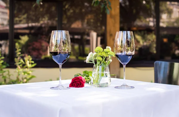 Flor de rosa con vino en la mesa en el restaurante - foto de stock
