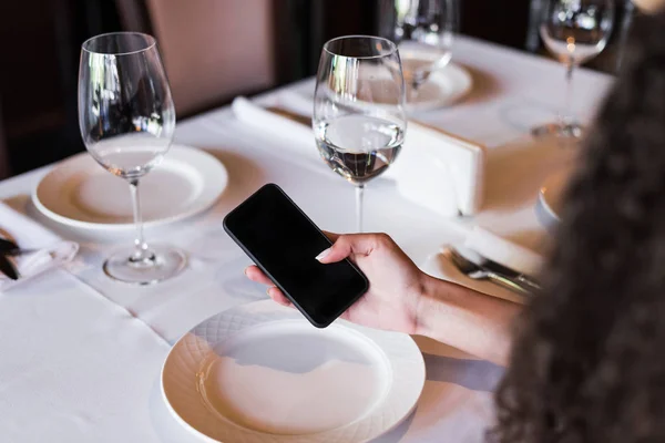 Mujer usando smartphone en restaurante - foto de stock