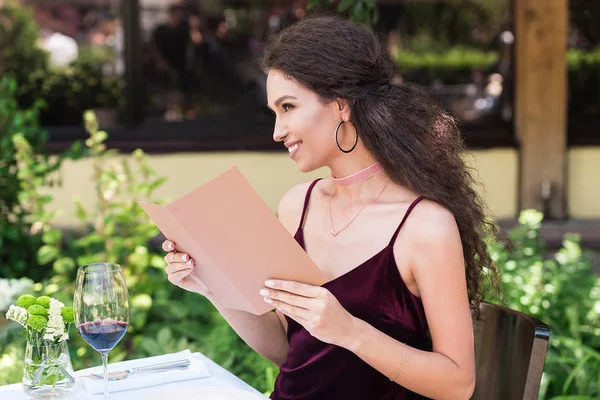 Femme avec menu au restaurant — Photo de stock