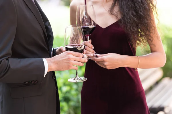 Couple standing with wine in garden — Stock Photo