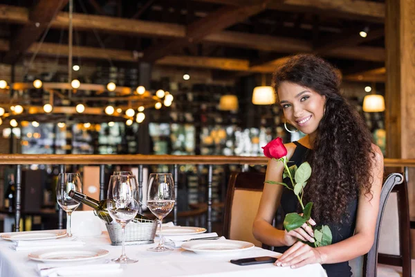 Жінка з трояндою в ресторані — стокове фото