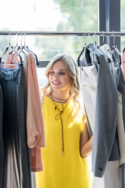 Mujer elegir ropa en la tienda - foto de stock