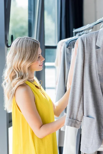 Женщина выбирает одежду в магазине — стоковое фото
